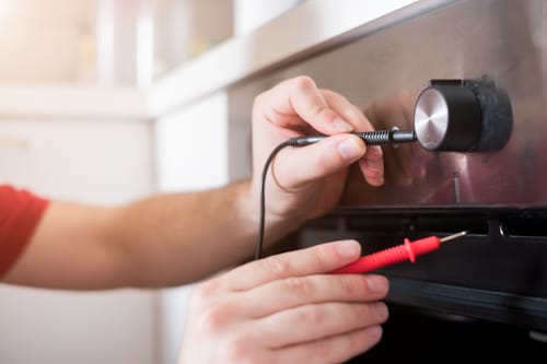 Professional worker repairing the oven